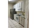 Kitchen with white appliances, ample cabinetry and neutral countertops, next to a door to a walk-in pantry at 7109 Yacht Basin Ave # 430, Orlando, FL 32835