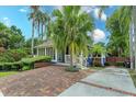 Inviting home featuring a brick driveway, mature palm trees, and well-maintained landscaping at 719 S Summerlin Ave, Orlando, FL 32801