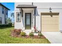 Welcoming front door with dark trim and stylish landscaping; garage door is to the right at 824 Longboat Dr, Davenport, FL 33896