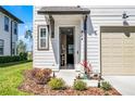 Inviting front entrance of a townhome with beautiful landscaping and a well-lit porch at 824 Longboat Dr, Davenport, FL 33896