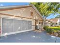 Exterior view featuring a spacious two-car garage and inviting front porch at 8787 Sw 90Th Ln # E, Ocala, FL 34481