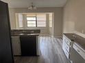 Kitchen with updated gray wood flooring, chandelier, and plenty of natural light from bay windows at 1060 Walt Williams Rd, Lakeland, FL 33809