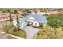 An aerial view of a home showcasing its pristine roof, three car garage, and lush surrounding neighborhood at 1403 Lake Whitney Dr, Windermere, FL 34786