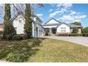 Charming home with a well manicured lawn, a stone accent, and three car garage under a vibrant sky at 1403 Lake Whitney Dr, Windermere, FL 34786