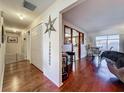 Hallway featuring gleaming hardwood floors, closet, and view of kitchen at 1617 E Sandpiper Trl, Casselberry, FL 32707