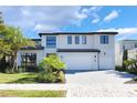 Lovely two-story home with modern curb appeal, a paved driveway and attractive tropical landscaping at 16728 Bolsena Dr, Bella Collina, FL 34756