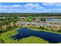 An aerial view of homes in a residential area near a pond at 17319 Million Lakes Ct, Clermont, FL 34714