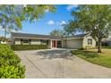 A beautifully landscaped home with a circular driveway and an attached two-car garage at 230 S Ranger Blvd, Winter Park, FL 32792