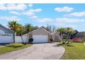 Single Gathering home with a long driveway, palm trees, and well-kept lawn at 3043 Autumn Run Ct, Orlando, FL 32822