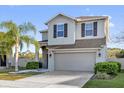 Charming two-story home featuring a well-manicured lawn, palm tree, and a two car garage at 3179 Turret Dr, Kissimmee, FL 34743