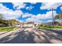 Gated entry to a grey house featuring a screened in pool with lush lawns at 372 Rest Haven Rd, Geneva, FL 32732