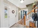 Warm entryway featuring brick flooring, a staircase, and a decorative wreath on the front door at 7279 Nena Ct, Mount Dora, FL 32757