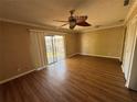 A well-lit living room with laminate flooring, a ceiling fan, and sliding glass doors to the lanai at 7309 Daniel Webster Dr # D, Winter Park, FL 32792