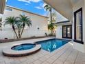 Backyard pool with a spa, surrounding pavers and manicured landscaping around the perimeter at 7548 Gathering Dr, Reunion, FL 34747