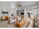 Bright living room featuring neutral tones, modern furniture, and an open layout to the kitchen and dining area at 9700 Sw 194Th Cir, Dunnellon, FL 34432