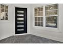 Modern front entry with a stylish black door, sidelight windows and brick-paved porch at 10148 Chiltern Garden Dr, Orlando, FL 32827