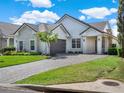 Charming single-Gathering home with a brick driveway, manicured lawn, and inviting curb appeal at 10148 Chiltern Garden Dr, Orlando, FL 32827