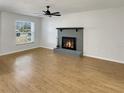 Open concept living room features a gray brick fireplace, wood-look flooring, and plenty of natural light at 120 Mayfair Ct # 120, Sanford, FL 32771