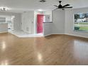 Bright living room showcasing wood-look floors, ceiling fan, and a seamless transition to the kitchen area at 120 Mayfair Ct # 120, Sanford, FL 32771
