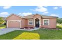 Single story home with two-car garage, neutral paint and manicured lawn at 1380 Normandy Heights Cir, Winter Haven, FL 33880