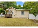 Rear exterior view of this charming home features a well-maintained lawn and partially fenced yard at 1401 E Voorhis Ave, Deland, FL 32724