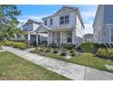 Attractive two-story home with landscaped front yard, side lawn, and covered porch with stately columns at 14317 Lanikai Beach Dr, Orlando, FL 32827