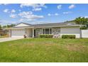 Charming single-story home with stone accents, a two-car garage, and a well-manicured lawn at 1484 Patricia St, Kissimmee, FL 34744
