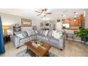 Living room boasts a comfortable gray sectional sofa, leading to the kitchen with a breakfast bar at 1625 Smokey Oak Way, Longwood, FL 32750