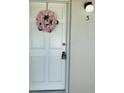 Entrance with a pink floral wreath hanging on the door and with a visible unit number at 1935 Conway Rd # R5, Orlando, FL 32812