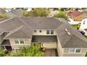 Aerial view of a townhome featuring a new roof, brick-paved driveway, and lush landscaping at 2026 Cypress Bay Blvd, Kissimmee, FL 34743