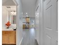 Hallway view including a full bath, linen closet, and a kitchen in a home with gray wood flooring at 2026 Cypress Bay Blvd, Kissimmee, FL 34743