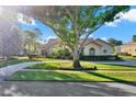 Charming single-story home with a circular driveway and beautifully landscaped front yard, framed by a mature shade tree at 2230 Lake Crescent Ct, Windermere, FL 34786