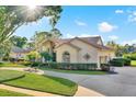 A bright and inviting single-story home with lush landscaping and a circular driveway on a sunny day at 2230 Lake Crescent Ct, Windermere, FL 34786