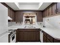 Functional kitchen with white appliances, laminate countertops, and dark wood cabinetry at 2522 Junction Rd, Zellwood, FL 32798