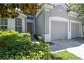 Inviting home exterior featuring a two-car garage, complemented by lush landscaping and a warm entryway at 2631 Archfeld Blvd, Kissimmee, FL 34747