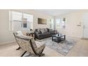 Comfortable living room featuring a gray sofa, tile flooring, and natural light from multiple windows at 277 Sand Ridge Dr, Davenport, FL 33896