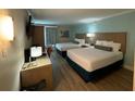 Well-lit hotel room with two beds, desk, task lighting, tv, bureau and pleasing decor at 3000 Maingate Ln # 520, Kissimmee, FL 34747