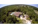 Stunning aerial view of a home with a private pool, circular driveway, and lush landscaping surrounded by mature trees at 3150 Appaloosa Ct, Kissimmee, FL 34746