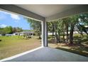 Covered patio with expansive backyard view and mature trees creates a peaceful outdoor living space at 328 Woodland Trl, Lady Lake, FL 32159