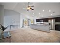 Bright open-concept living space flows into the kitchen, featuring modern lighting and neutral tones at 328 Woodland Trl, Lady Lake, FL 32159