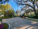 Elegant gated community entrance with lush landscaping and brick paver driveway at 3687 Farm Bell Pl, Lake Mary, FL 32746