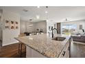 Gleaming granite countertops highlight the kitchen island with seating and pendant lighting above at 4439 Davos Dr, Clermont, FL 34711
