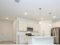Modern kitchen featuring stainless steel appliances, white cabinets, and an island at 4765 Sw 128Th St, Ocala, FL 34473