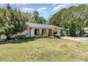 The exterior of a charming single-story house features arched entrances and a lush front lawn at 6 Winding Ridge Rd, Casselberry, FL 32707