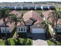 Aerial view of a single-story home featuring a tile roof, two-car garage, and landscaping within a residential community at 631 Tuscan Hills Blvd, Davenport, FL 33897