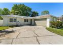 The exterior of the home shows a paved driveway leading to the garage, and manicured shrubs by the entrance at 7600 Boreas Dr, Orlando, FL 32822