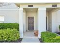 Inviting front porch with covered entrance, complemented by lush greenery and a quaint bench at 8959 Stinger Dr, Champions Gate, FL 33896