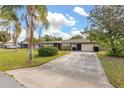 Charming single story home featuring a well-maintained lawn, mature landscaping, and a concrete driveway at 1061 Radford Dr, Deltona, FL 32738