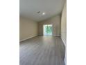 Spacious living room featuring wood-look flooring, recessed lighting, and sliding doors to a backyard view at 1328 Burnley Ct, Kissimmee, FL 34758