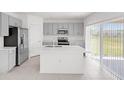 Bright kitchen features stainless steel appliances, center island and sliding glass doors at 144 Jones Fish Camp Rd, Edgewater, FL 32141
